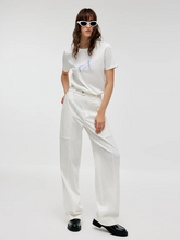 a lady wears a white cargo pants with white T-shirt